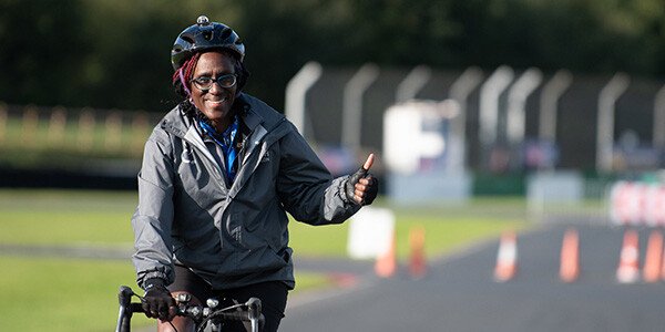 female technical official on the bike course smiling at the camera gesturing with a thumbs up